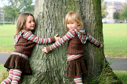 Sisters hugging a tree